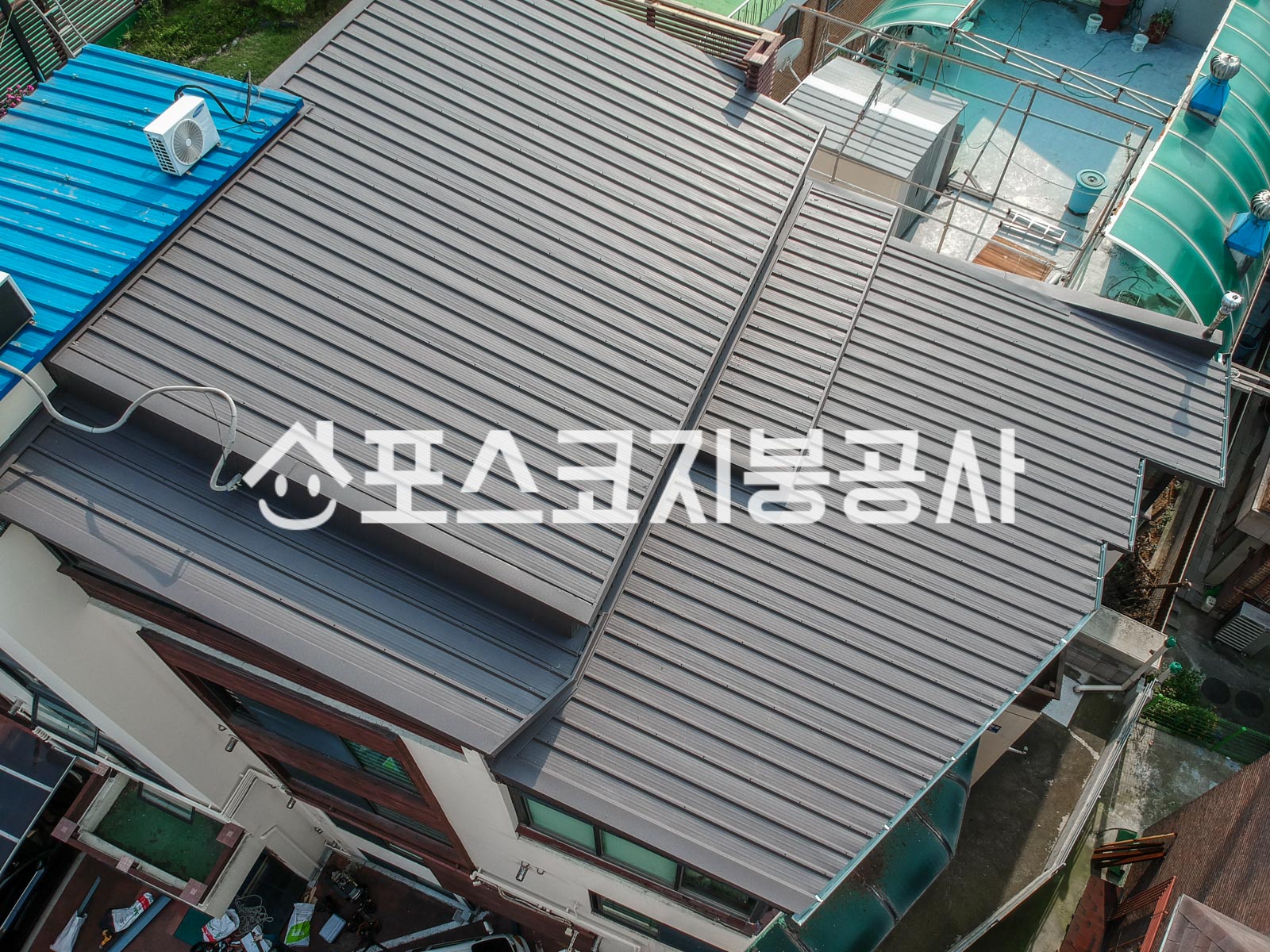 주택 옥상을 낮은 경사의 칼라강판으로 덮어 빗물이 건물 밖으로 빠지게 한 모습